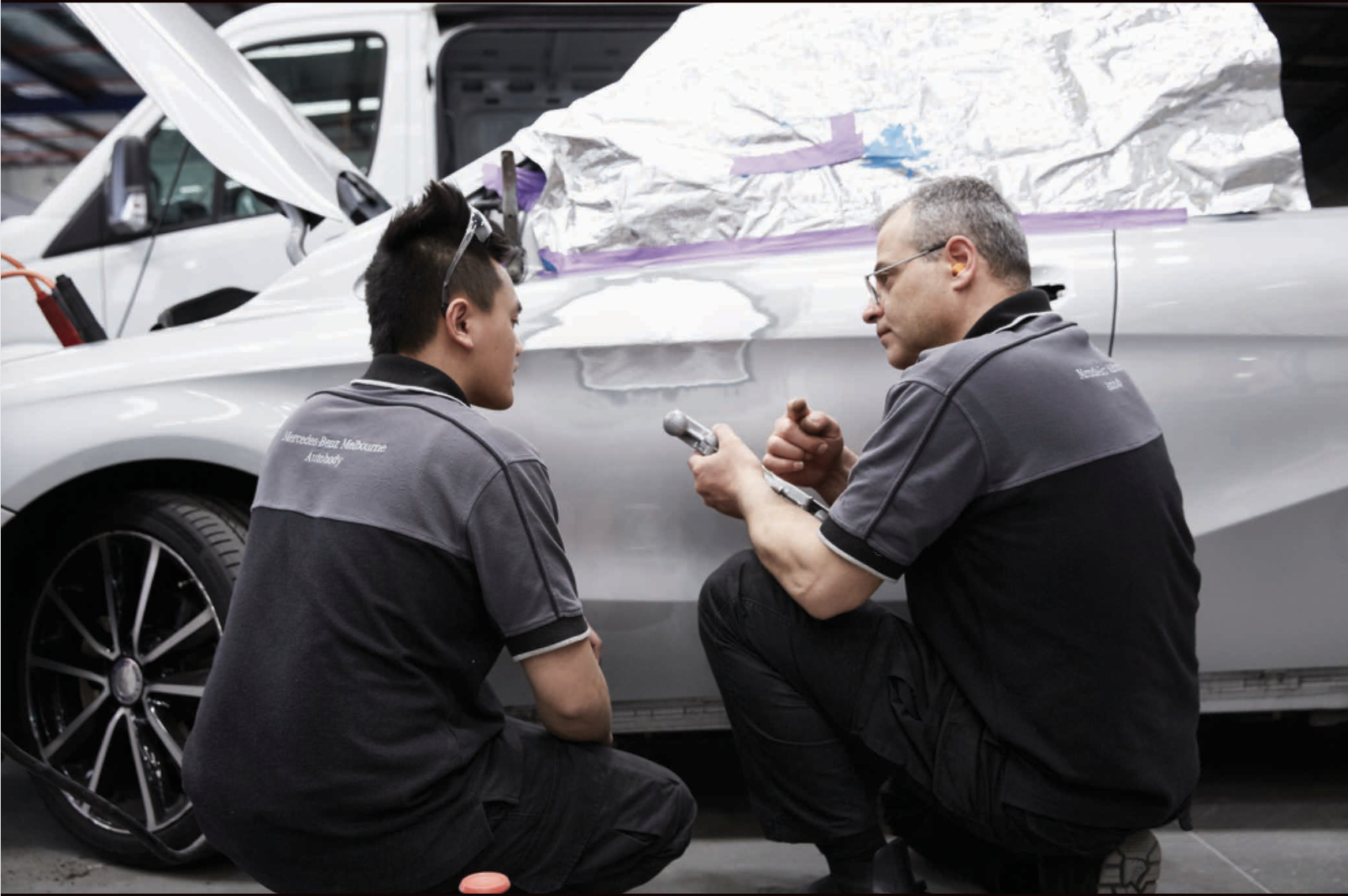 Miranda Auto Body technicians inspecting Mercedes panel damage